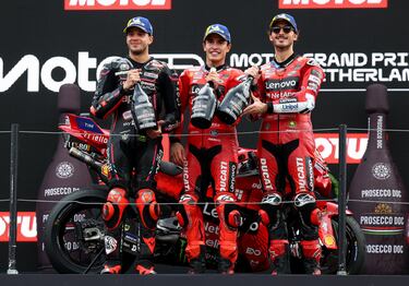 Los pilotos en el podio tras terminar la carrera, Marc Márquez celebra su victoria desde lo más alto escoltado por Marco Bezzecchi, que acabó segundo y Francesco Bagnaia, tercero.