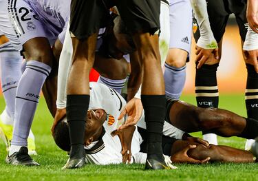 El defensa del Valencia se lleva las manos a la rodilla tras la acción accidental con Aurelien Tchouameni.