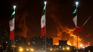FILE PHOTO: Iranian flags fly as fire and smoke from an Israeli attack on Sharan Oil depot rise, following Israeli strikes on Iran, in Tehran, Iran, June 15, 2025. Majid Asgaripour/WANA (West Asia News Agency) via REUTERS ATTENTION EDITORS - THIS PICTURE WAS PROVIDED BY A THIRD PARTY/File Photo