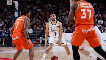 El escolta argentino del Real Madrid Facundo Campazzo (c) controla un balón ante Chris Jones (i) escolta armenio del Valencia Basket durante el partido correspondiente a la jornada 16 de la Liga Endesa que ambos clubes disputan este domingo en el WiZink Center, Madrid.