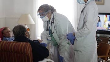 Un grupo de médicos atienden a dos personas mayores.