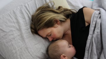 A nine month old baby girl is cuddled by her mother while asleep in bed. Photo Tim Clayton (Photo by Tim Clayton/Corbis via Getty Images)