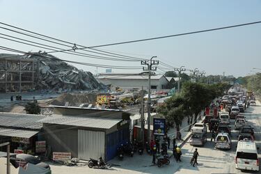 Coches en una carretera cerca de un edificio que se derrumbó después de que un fuerte terremoto sacudiera el centro de Myanmar.