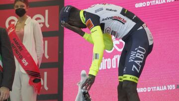 El ciclista eritreo Biniam Girmay se lleva la mano al ojo tras el golpe que recibió al descorchar el champán en el podio como ganador de la décima etapa del Giro de Italia en Jesi.