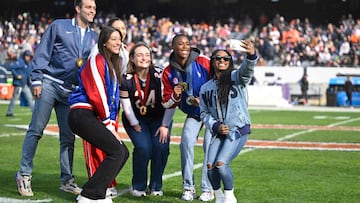 CHICAGO, ILLINOIS - NOVEMBER 24: Simone Biles (R) and other Olympians from Illinois take a selfie on the field during halftime of a game between the Chicago Bears and the Minnesota Vikings at Soldier Field on November 24, 2024 in Chicago, Illinois. Quinn Harris/Getty Images/AFP (Photo by Quinn Harris / GETTY IMAGES NORTH AMERICA / Getty Images via AFP)
