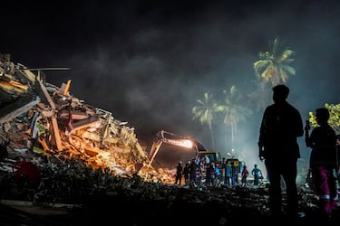 La gente observa mientras continúan las operaciones de búsqueda y rescate tras un fuerte terremoto en Mandalay, Myanmar.