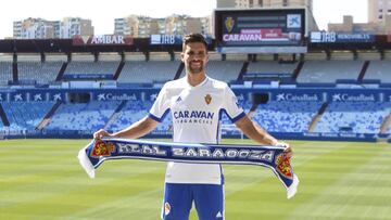 Adrián González posa con una bufanda del Real Zaragoza en su presentación en La Romareda.