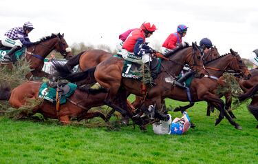 El hipódromo de Aintree, en Liverpool, se prepara para la cita más importante del año: el Grand National, que tendrá lugar mañana tras el Día de las Damas de hoy. Sin embargo, la fiesta de las carreras se empezó a vivir desde ayer. En la imagen, el jockey Ben Sutton se protege tras caer de Drop Flight para evitar ser pisado por los caballos.