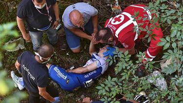 TOPSHOT - Deceuninck - Quick Step Belgium rider Remco Evenepoel is helped by staff member and medical staff as he lies down after crashed during the 114th edition of the giro di Lombardia (Tour of Lombardy), a 231 km cycling race from Bergamo to Como on A