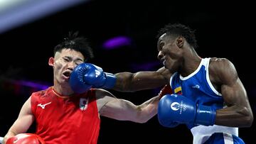 Japan's Shudai Harada (in red) takes a punch from Colombia's Yilmar Leandro Gonzalez Landazury in the men's 57kg preliminaries round of 16 boxing match during the Paris 2024 Olympic Games at the North Paris Arena, in Villepinte on July 31, 2024. (Photo by MOHD RASFAN / AFP)