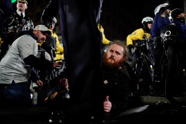 Un hombre observa mientras la policía se enfrenta a los fanáticos que se reunieron para celebrar después del triunfo de los Philadelphia Eagles.