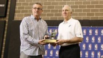 R. C. Buford, general manager de los Spurs, entrega el Trofeo Red Auerbach a Gregg Popovich.
