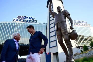 El dueño de los Patriots, Robert Kraft, charla con Tom Brady a los pies de la nueva estatua inaugurada en homenaje al fantástico jugador.
