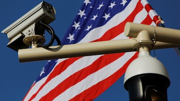 Cámaras de vigilancia con la bandera de Estados Unidos de fondo.