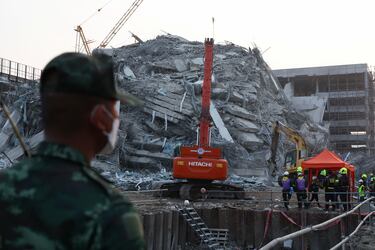El personal de rescate trabaja con maquinaria pesada entre los escombros de un edificio que se derrumbó tras un fuerte terremoto en Bangkok, Tailandia.