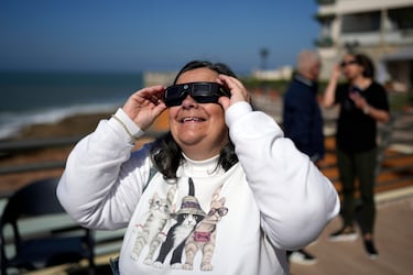 Una mujer se pone unas gafas para poder visualizar el eclipse solar.