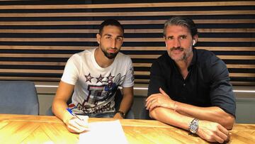 José Rodríguez firma contrato. A su izquierda, Caminero.