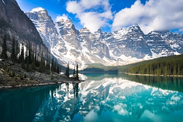 Un lago de color turquesa en el Parque Nacional de Banff, rodeado de montañas y bosques.