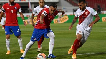 Chile's Fabian Orellana (C) is challenged by Peru's Miguel Trauco during their closed-door 2022 FIFA World Cup South American qualifier football match at the National Stadium in Santiago, on November 13, 2020. (Photo by MARTIN BERNETTI / POOL /