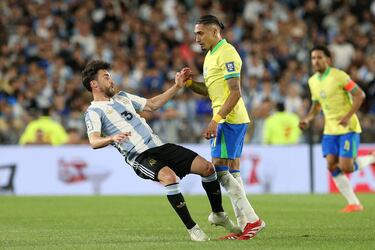 Nicolas Tagliafico cae sobre el terreno de juego ante el brasileño Raphinha.