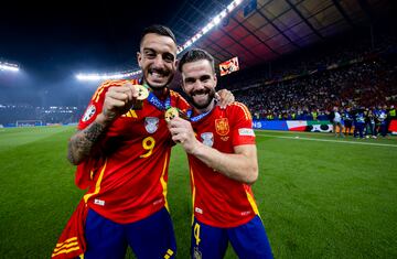 Joselu y Nacho Fernández, muestran sus medallas que les acreditan campeones de la Eurocopa.