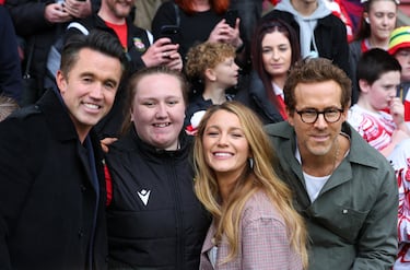 El actor y dueño del Wrexham, Rob McElhenney y Ryan Reynolds, junto a la actriz Blake Lively, se toman un selfie con un aficionado antes del partido.