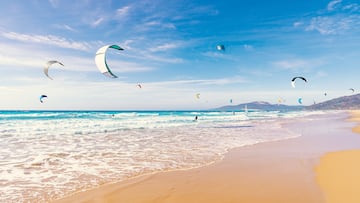 Tarifa beach in Cadiz surf city skyline of Andalusia Spain with lots of kitesurfing kites under blue sunny sky
