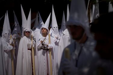 Penitentes de la Hermandad de la Paz participan en una procesión el Domingo de Ramos en Sevilla. 