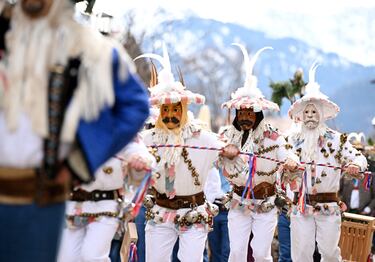 Los bufones del carnaval vestidos con trajes tradicionales bailan en una calle de Mittenwald, Alemania.