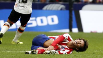João Félix llevándose las manos a su tobillo derecho con gesto de dolor en el partido ante el Valencia del Atlético en la 2020-21. Hoy se operará de éste.