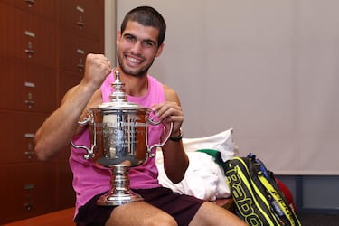 El tenista español Carlos Alcaraz posa con su trofeo en el vestuario tras derrotar al italiano Jannik Sinner en la final individual masculina, en la decimoquinta jornada del Abierto de Estados Unidos 2025.