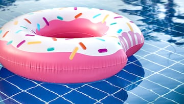 Inflatable accessories for swimming in the pool . In the form of inflatable large pink doughnut. The concept of summer vacation.