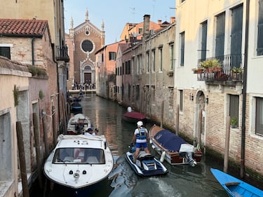 Policías en motos acuáticas patrullan un canal. Al fondo se ve la iglesia de la Madonna dell'Orto.