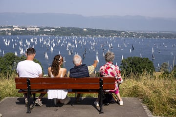 Cuatro privilegiados espectadores observan, desde un banco de madera en una zona elevada, la salida de la 86ª edición de la regata Bol dOr, que tiene lugar en el lago Lemán o lago de Ginebra, en Suiza. Alrededor de 404 embarcaciones participan durante el fin de semana en la mayor regata de vela celebrada en el mayor lago de la Europa Occidental.