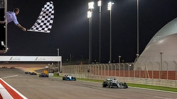 El ex jugador de fútbol británico David Beckham ondea la bandera a cuadros cuando el piloto británico de Mercedes, Lewis Hamilton, cruza la línea de meta durante el Gran Premio de Fórmula Uno de Bahrein en el circuito de Sakhir