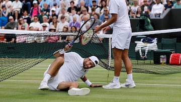 Karen Khachanov pasa por debajo de la red en su partido contra Kamil Majchrzak en Wimbledon.