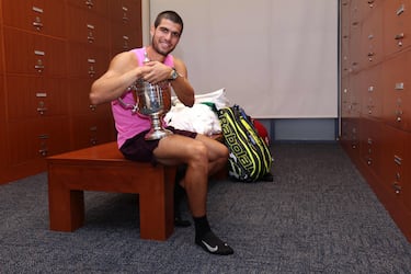 El tenista español Carlos Alcaraz posa con su trofeo en el vestuario tras derrotar al italiano Jannik Sinner en la final individual masculina, en la decimoquinta jornada del Abierto de Estados Unidos 2025.