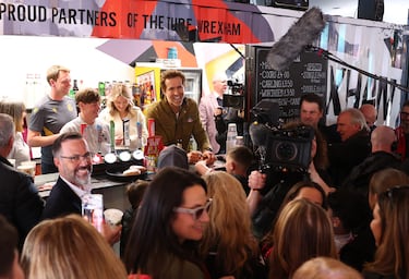 El actor y copropietario del Wrexham, Ryan Reynolds, tras el mostrador de un puesto de comida antes del partido.