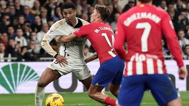 Real Madrid's English midfielder #5 Jude Bellingham fights for the ball with Atletico Madrid's Spanish midfielder #14 Marcos Llorente during the Spanish league football match between Real Madrid CF and Club Atletico de Madrid at the Santiago Bernabeu stadium in Madrid on February 4, 2024. (Photo by Thomas COEX / AFP)