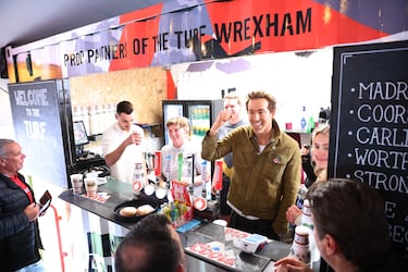 El actor y copropietario del Wrexham, Ryan Reynolds, tras el mostrador de un puesto de comida antes del partido.