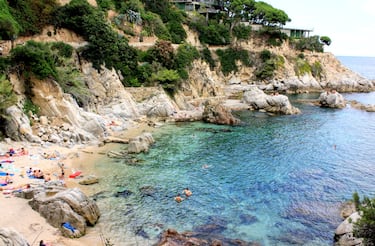 
Cala Trons, en Lloret de Mar, es una cala pequeña y escondida que ofrece una experiencia íntima y auténtica. Rodeada de rocas y vegetación mediterránea, sus aguas transparentes son ideales para el snorkel y el baño tranquilo. De acceso a pie por el Camino de Ronda, garantiza una visita alejada del turismo masivo.   