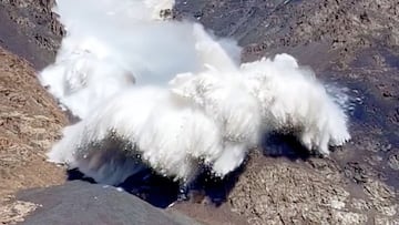 Hielo y nieve chocando contra una piedra y saltando por los aires en una avalancha producida por el colapso de un glaciar en las montañas de Tian Shan, Kirguistán.