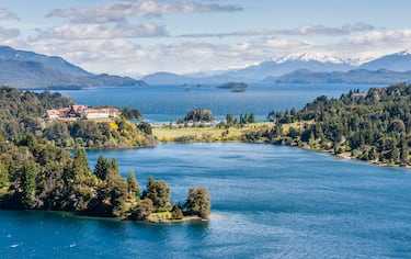 Un lago de origen glaciar rodeado de montañas y bosques, ideal para actividades al aire libre.