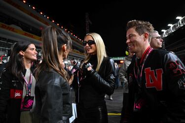 El snowboarder Shaun White (a la derecha), presencia el saludo entre su pareja, la actriz canadiense Nina Dobrev, y Paris Hilton.