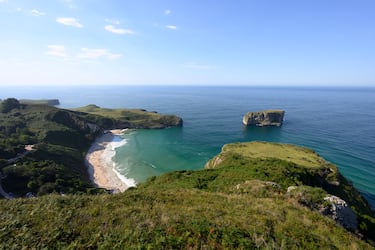 Aguas tranquilas y de poco oleaje, arena fina y blanca y un paisaje coronado por el islote del Castro es lo que encontraremos en la Playa de Ballota. Uno de sus atractivos lo encontraremos durante la pleamar, pues el agua impacta contra las rocas y sube a través de la chimenea natural abierta en el acantilado.