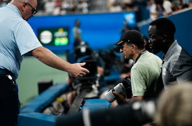 Un miembro del staff acompaña al fotógrafo implicado en el lío durante el partido entre el francés Benjamin Bonzi y el ruso Daniil Medvedev.