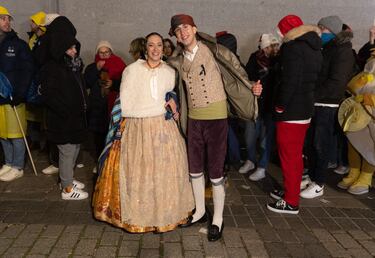 Dos personas vestidas con trajes regionales hacen cola antes de pasar a la celebración del Sorteo Extraordinario de la Lotería de Navidad 2024.