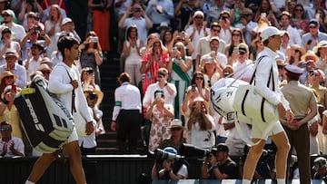 Spain's Carlos Alcaraz (L) and Italy's Jannik Sinner arrive on court for their men's singles final tennis match on the fourteenth day of the 2025 Wimbledon Championships at The All England Lawn Tennis and Croquet Club in Wimbledon, southwest London, on July 13, 2025. (Photo by HENRY NICHOLLS / AFP) / RESTRICTED TO EDITORIAL USE