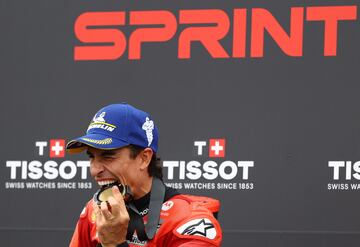 Marc Marquez celebra mordiendo su medalla tras ganar otra carrera al esprint, la décima de once disputadas.