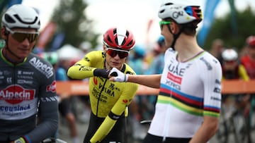 UAE Team Emirates' Slovenian rider Tadej Pogacar (R) fist bumps with Team Visma-Lease a Bike's Danish rider Jonas Vingegaard prior to the start of the 1st stage of the 77th edition of the Criterium du Dauphine cycling race, 195,8 km between Dom�rat and Montlucon, on June 8, 2025. (Photo by Anne-Christine POUJOULAT / AFP)